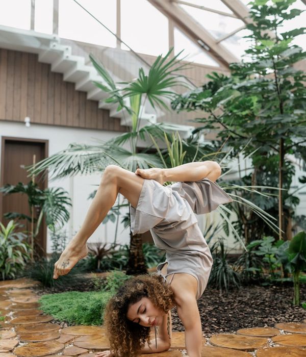 Woman in a graceful yoga pose with emerald green light accents.